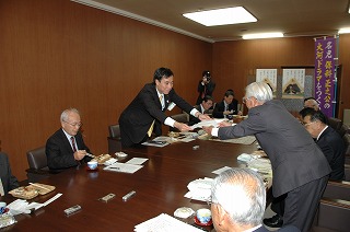 写真：つくる会の堀井さんから保科正之公に関する資料を受け取る阿部知事