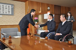 写真：記念品を贈り、樋口選手と握手を交わす阿部知事