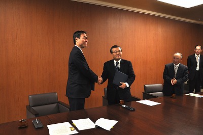 写真：調印後握手を交わす青木社長と阿部知事