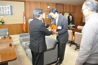 写真：お土産のコニャックを受け取る阿部知事