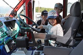 写真：消防車のハンドルを握る子どもたち