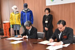 写真：協定書にサインする辰野氏と阿部知事