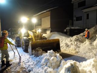 写真：夜間作業する除雪車
