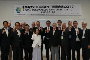 写真：地域再生可能エネルギー国際会議で人差し指を立てて記念撮影する中島副知事などの会議出席者