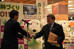 写真：森林大使に任命されたC・W二コル氏と握手を交わす知事