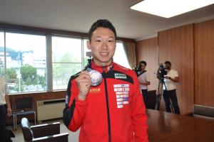 写真：銀メダルを持って記念撮影する西藤選手